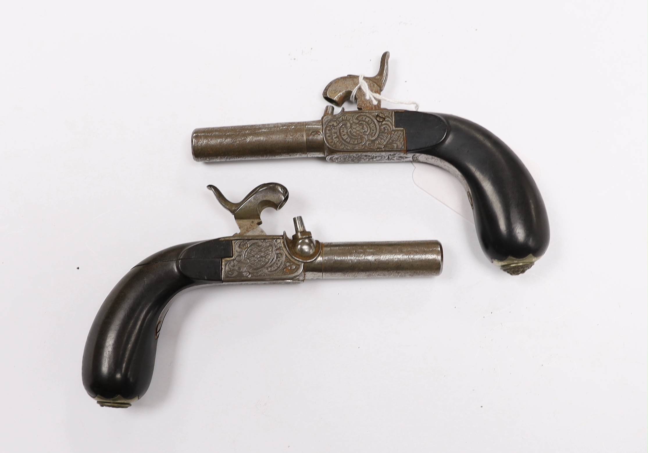 A pair of 19th century box lock, percussion pistols, with turn off Damascus twist barrels, engraved frames, folding triggers, and rounded ebony grips fitted with hinged butt cap lids, barrels 4.8cm